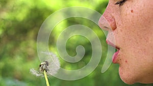 Beautifull girl blow on dandelion slow motion