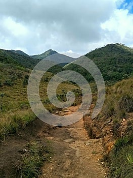 Beautifull landscape of mountains through the sandy trail between grasslands of Horton Plains, Nuwara Eliya, Sri Lanka.