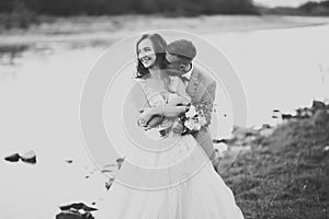 Beautifull wedding couple kissing and embracing near the shore of a mountain river with stones