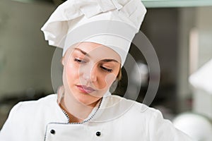 A beautifull young female chef posing for camera