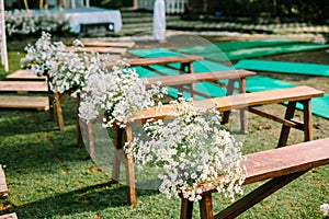 Beautifully adorned wooden chairs embellished with wedding floral decorations,