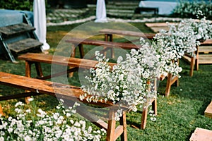 Beautifully adorned wooden chairs embellished with wedding floral decorations,