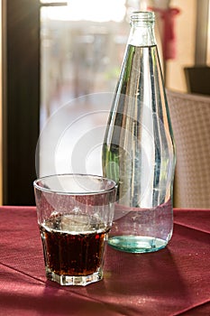 A beautifully backlit glass of red soft drink on a restaurant table