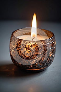 A beautifully burning thick, ornate candle.