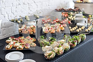 Beautifully decorated catering banquet table with different food snacks and appetizers.