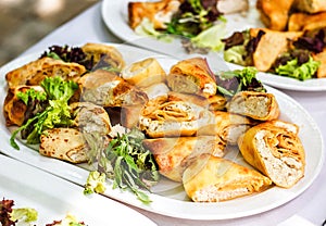 Beautifully decorated catering banquet table with different food snacks and appetizers with sandwich, pancakes, fresh salad on cor photo