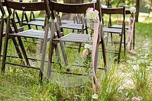 Beautifully decorated chairs for wedding reception outdoors.