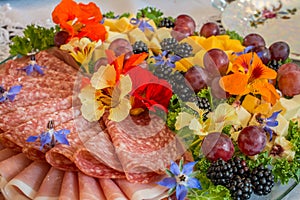 Beautifully decorated home made  salads with edible flowers  on table with different food snacks  party