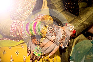 Beautifully decorated Indian bride hands with the groom.