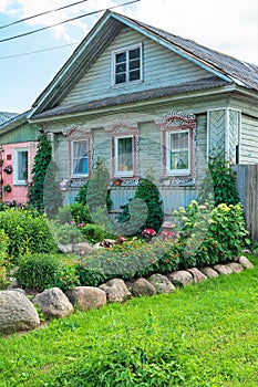 Russia, Uglich, July 2020. A small green garden in front of the facade of an old Russian wooden house.