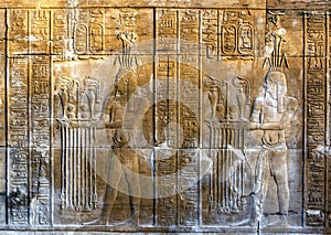 A beautifully decorated wall displaying engravings and hieroglyphs at the Temple of Kom Ombo in Egypt.