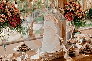 Beautifully decorated wedding ceremony table with a cake and vibrant flowers