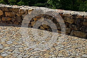 Beautifully folded retaining wall of rough stone joined with cement mortar. brown beige yellow irregular limestone stone. holding