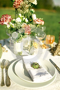 Beautifully laid a festive table for two in the garden with flowers