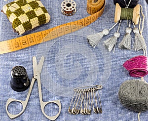 Beautifully laid out accessories for needlework on a jeans background