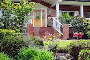 Beautifully landscaped entrance to a large brick house in an exclusive Canadian neighbourhood