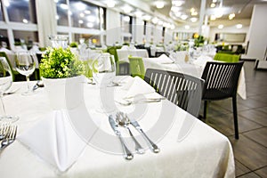 Beautifully organized event - served festive white tables ready for guests. Banquet, wedding decor, celebration.