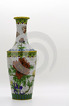 A beautifully ornamented cloisonne vase, with multi-colored flowers, on a white background