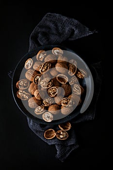 Beautifully presented walnuts on dark slate plate kitchen table