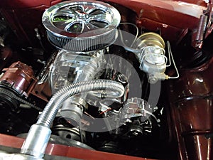 A beautifully restored classic car engine with chrome parts.