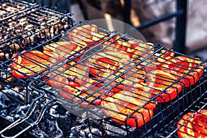 Beautifully roasted fresh juicy red bell peppers vegetables on the grill over low heat for preparing.