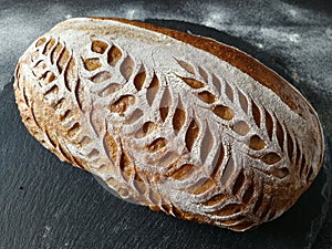 Beautifully scored homemade artisan sourdough bread photo