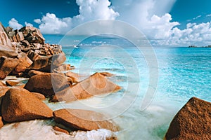 Beautifully shaped granite boulders and blue lagoon at Grand Anse beach, La Digue island, Seychelles