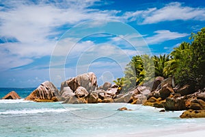 Beautifully shaped granite boulders, shallow tropical lagoon at pristine anse Cocos beach, La Digue island, Seychelles