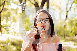 Beautifuln girl blowing soap bubbles