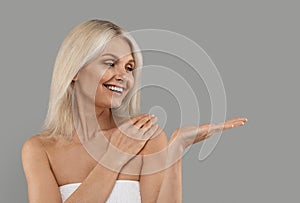 Beauty Ad. Smiling Attractive Mature Woman Holding Something On Her Empty Palm