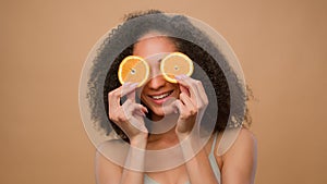 Beauty African American girl woman hold two half orange slices cover eyes dieting vegetarian body weight eco healthy