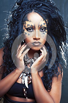 beauty afro girl with cat make up, creative leopard print on face closeup halloween woman