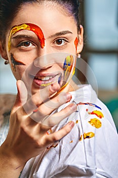 Beauty art concept, portrait of a young girl painted with different colors of paint. Color demos, colorful portrait