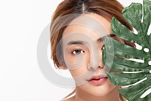 Beauty asian woman holds a large green tropical leaf in hands