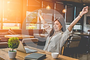 Beauty Asian woman raising two hands after finishing job happily