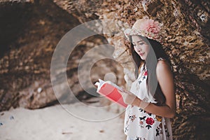 Beauty Asian woman reading book at beach. Lifestyles and Nature concept. Relaxation and leisure concept. Summer and tropical theme