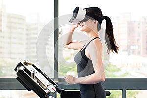 Beauty asian woman running treadmill by VR headset glasses