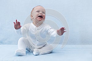 Beauty baby boy with expanded arms. Cute smiling joyful infant kid. Laughing toddler