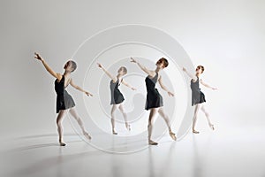 Beauty of ballet dance. Elegant teen girls, ballerinas in black leotards training, practicing against grey studio photo