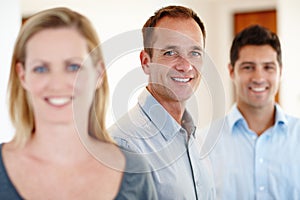 Beauty and the beasts. three office workers smiling and looking at the camera.