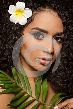 Beauty black skin woman fashion african ethnic female face portrait. Young girl model with afro and tropical leaves in hands