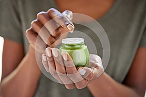 Beauty black woman holding a glass jar of skin cream