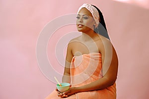 beauty black woman with perfect skin in towel clay body scrub application bowl looking away at copy space