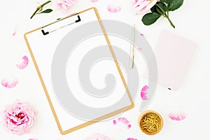 Beauty blog composition with dairy, pink roses bouquet and clipboard on white background. Top view. Flat lay.
