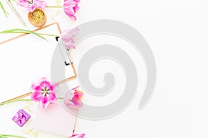 Beauty blog concept. Freelancer or blogger workspace with clipboard, notebook, pink tulips and accessories on white background. Fl