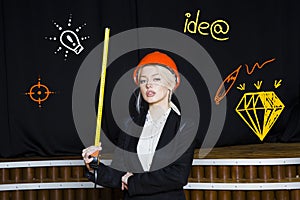 Beauty blonde businesswoman with designer or architect staff is standing against concrete wall with startup sketch on it