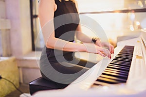Beauty Blonde Woman Portrait. Beautiful bride with long curly blond hair sitting at the piano. White Hair. Perfect Skin