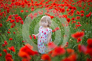 Beauty blue eyes teen enjoy summer days .Cute fancy dressed girl in poppy field. Field of blooming poppies