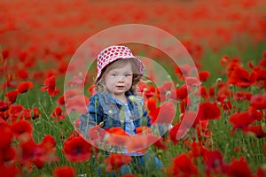 Beauty blue eyes teen enjoy summer days .Cute fancy dressed girl in poppy field. Field of blooming poppies