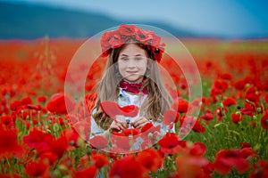 Beauty blue eyes teen enjoy summer days .Cute fancy dressed girl in poppy field. Field of blooming poppies